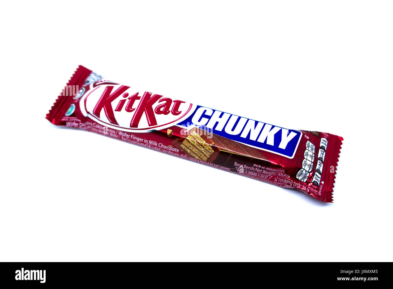 Kota Kinabalu, Malesia - Agosto 16, 2017: Kit Kat Chunky fetta dito nel latte aromatizzato al cioccolato isolato su sfondo bianco. Kit Kat barre sono produ Foto Stock