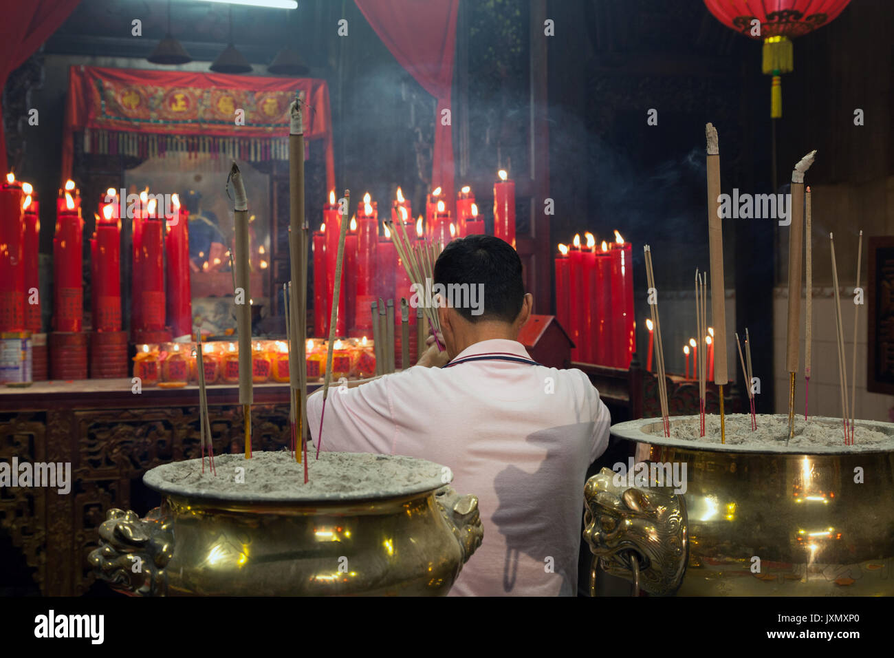 Georgetown, Malesia - 13 Febbraio 2016 : uomo che prega all'interno di un tempio cinese durante la festa di capodanno Foto Stock