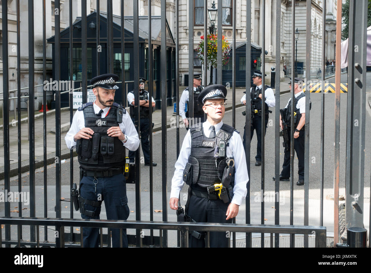 Polizia armata e cancelli di sicurezza guard l'ingresso a Downing St Westminster, London SW1A REGNO UNITO Foto Stock