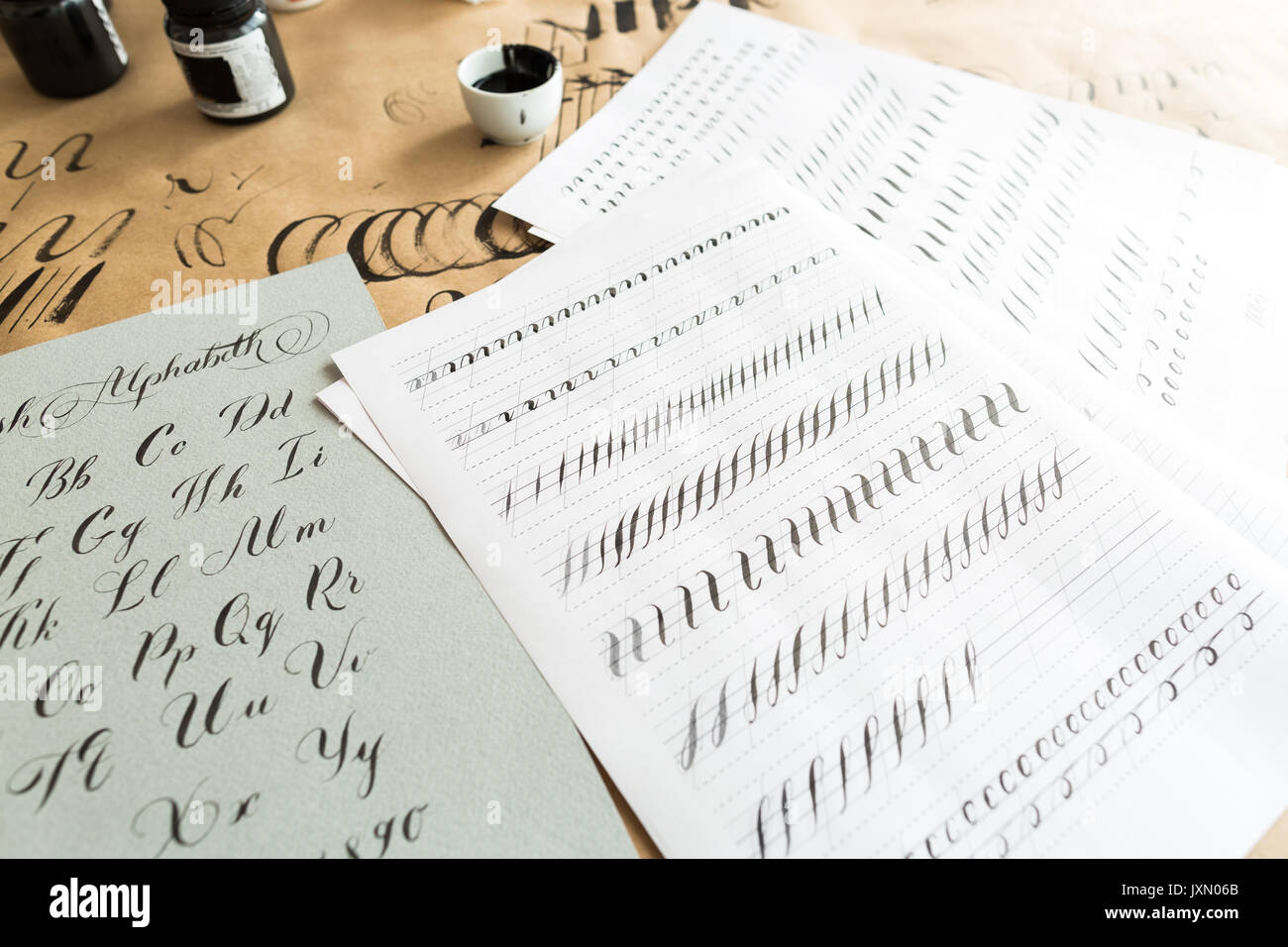 La calligrafia, istruzione, graphic design concept. partite di esercizi per la formazione della calligrafia con aiuto di forniture speciali come inchiostro nero, spazzole e bianco fogli rivestiti Foto Stock