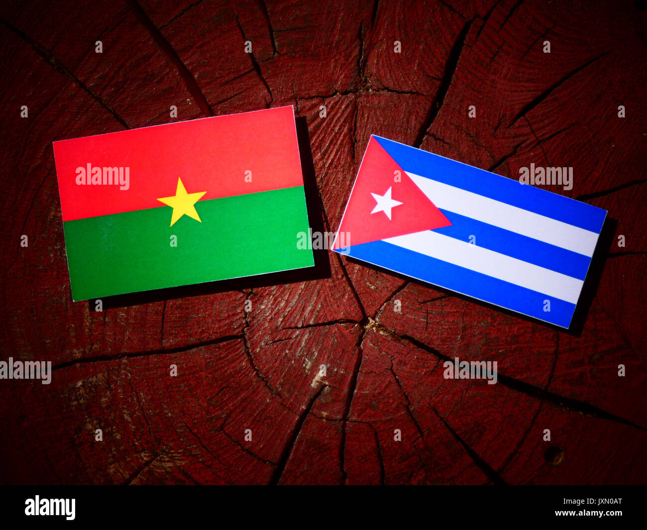 Il Burkina Faso bandiera con bandiera cubana su un ceppo di albero isolato Foto Stock