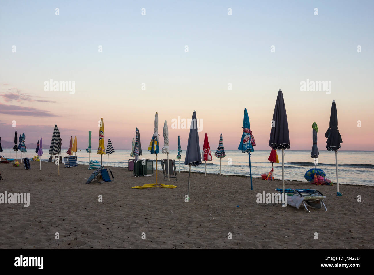 Tramonto sul Mar Tirreno, vista di frangiflutti e ombrelloni da spiaggia,  il porto e il mare di Terracina, Lazio, Italia Foto stock - Alamy