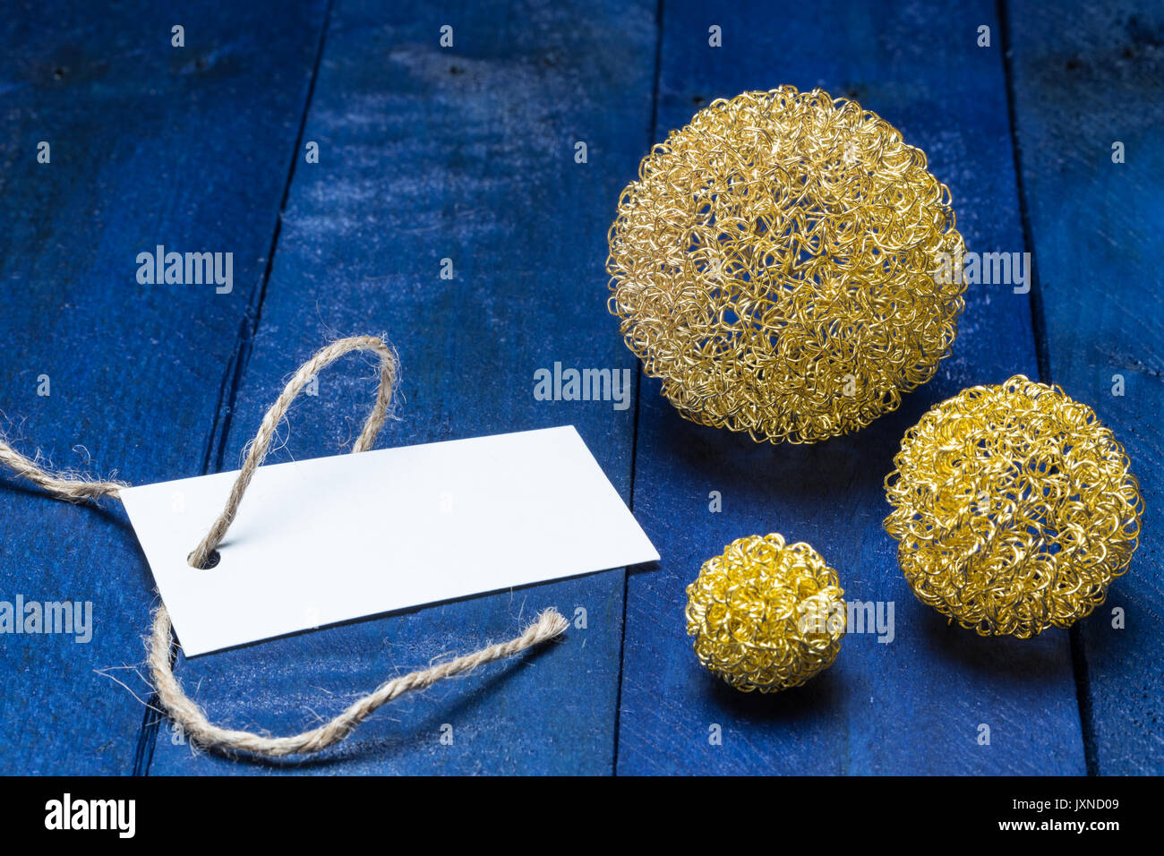 Scheda di invito con golden deco palle su legno blu. Foto Stock