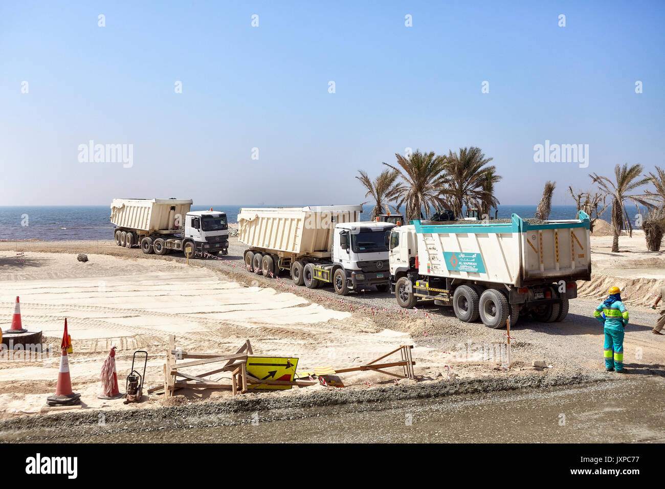 Dubai, Emirati Arabi Uniti - 03 Maggio 2017: autocarri con cassone ribaltabile su un sito in costruzione lungo la strada tra Dubai e Sharjah. Foto Stock