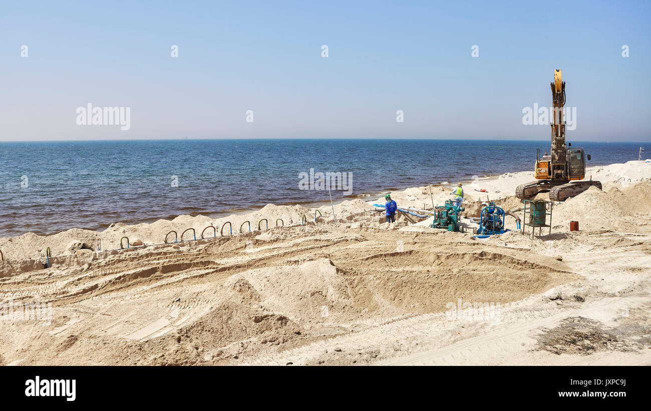 Dubai, Emirati Arabi Uniti - 03 Maggio 2017: i lavoratori a una spiaggia sito in costruzione tra Dubai e Sharjah. Foto Stock