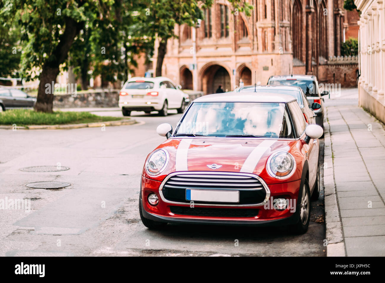 Vilnius, Lituania - 7 Luglio 2016: Colore rosso auto con strisce bianche Mini Cooper parcheggiata su Strada nella vecchia parte della città europea. Foto Stock