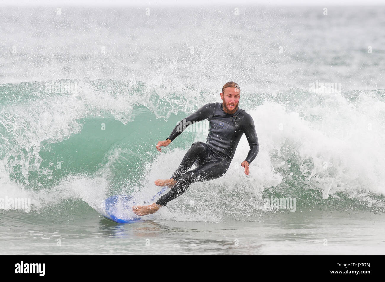 Metà maschio adulto cadere un'onda surf in Cornovaglia, England, Regno Unito Foto Stock