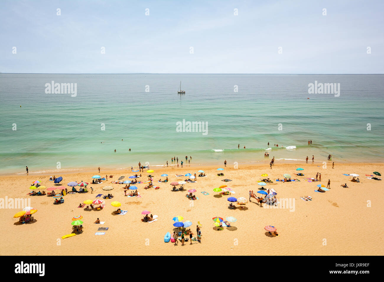 Vista dalla scogliera alla trafficata spiaggia Praia do Porto de Mos vicino a Ponta da Piedade, Lagos Algarve Portogallo Foto Stock