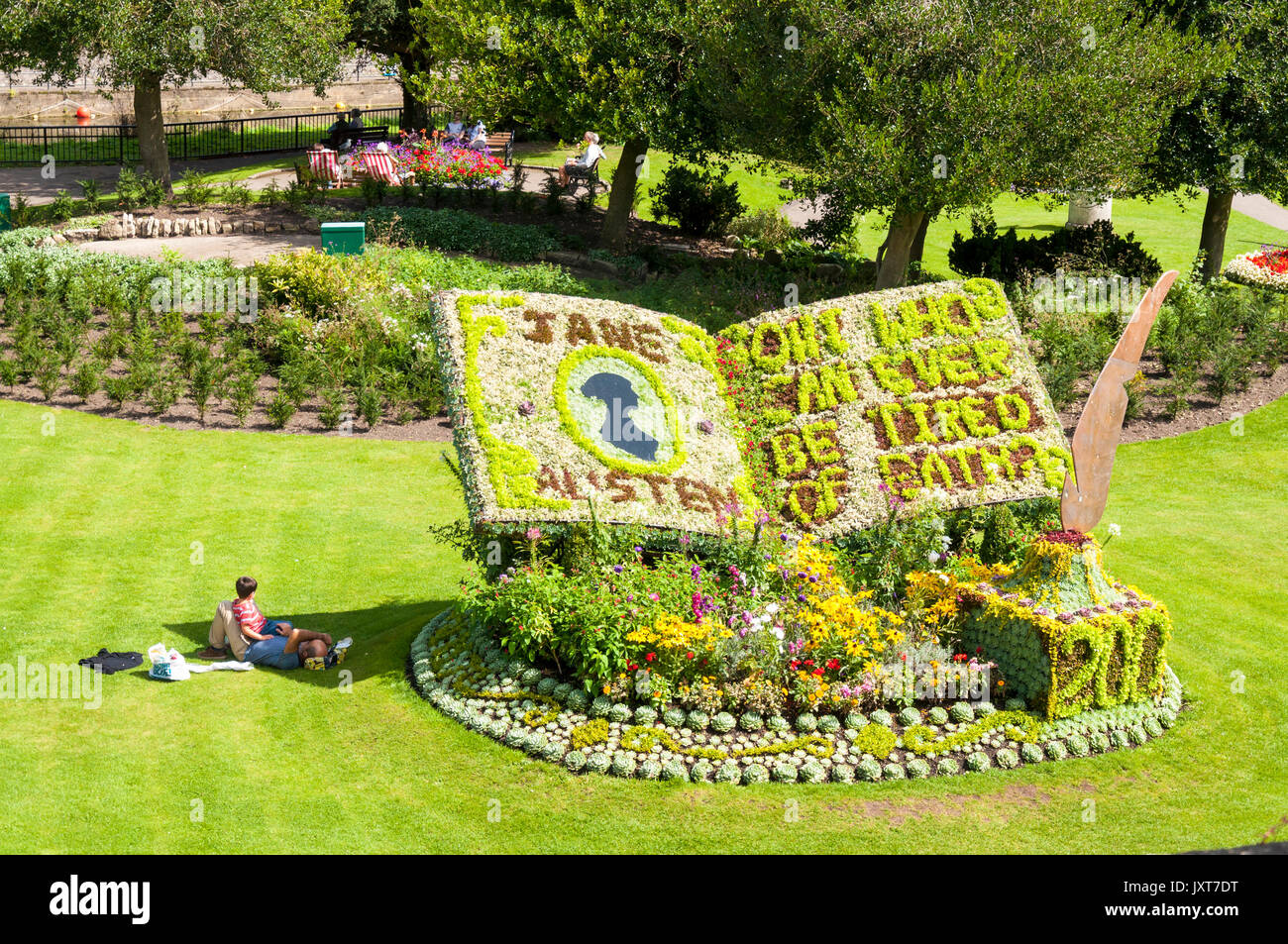 Bagno, Somerset, Regno Unito. 17 Ago, 2017. Regno Unito Meteo. Persone godetevi il sole e un omaggio floreale per la annuale internazionale di Jane Austen Festival in Bath Regno Unito. 2017 è un importante anno del bicentenario essendo entrambi il duecentesimo anniversario della la morte dell'autore e la pubblicazione del suo bagno due romanzi Northanger Abbey e persuasione, in parata giardini nel centro della città termale. Credito: Richard Wayman/Alamy Live News Foto Stock