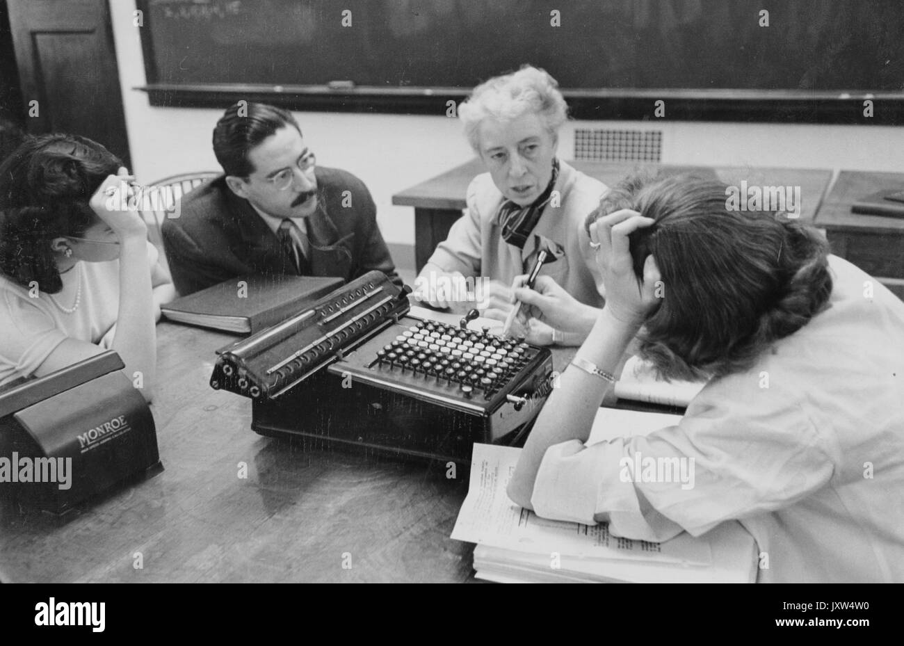 William Bennett kouwenhoven, biostatistica conferenza gruppo di persone non identificate parlando a un tavolo con i nastri inchiostratori per macchine da scrivere visibile, 1950. Foto Stock