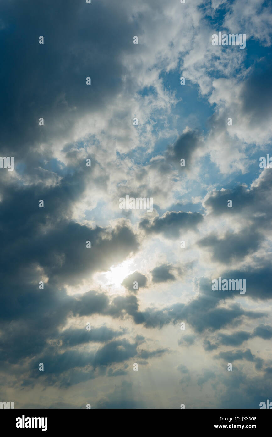 Raggi solari colpisce attraverso le nuvole in cielo blu, sullo sfondo della natura Foto Stock