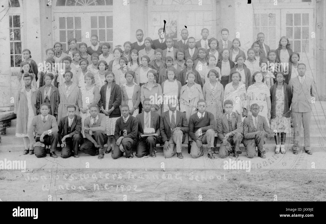 Ritratto a lunghezza intera di una classe co-ed di studenti neri con due insegnanti, tutti gli studenti che indossano uniformi; Winton, NC, 1920. Foto Stock