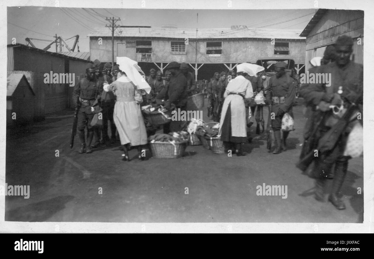 Due donne stanno dando gli uomini afroamericani piccoli sacchetti, 1929. Foto Stock