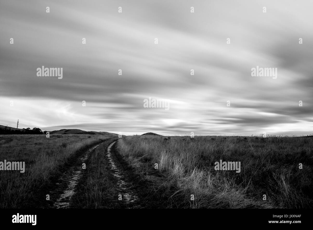 Una vista di una strada di montagna con un tetto in movimento delle nuvole Foto Stock