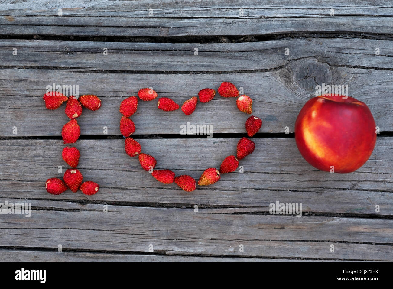 Testo io amo le pesche noci o frutta di legno su sfondo grigio Foto Stock