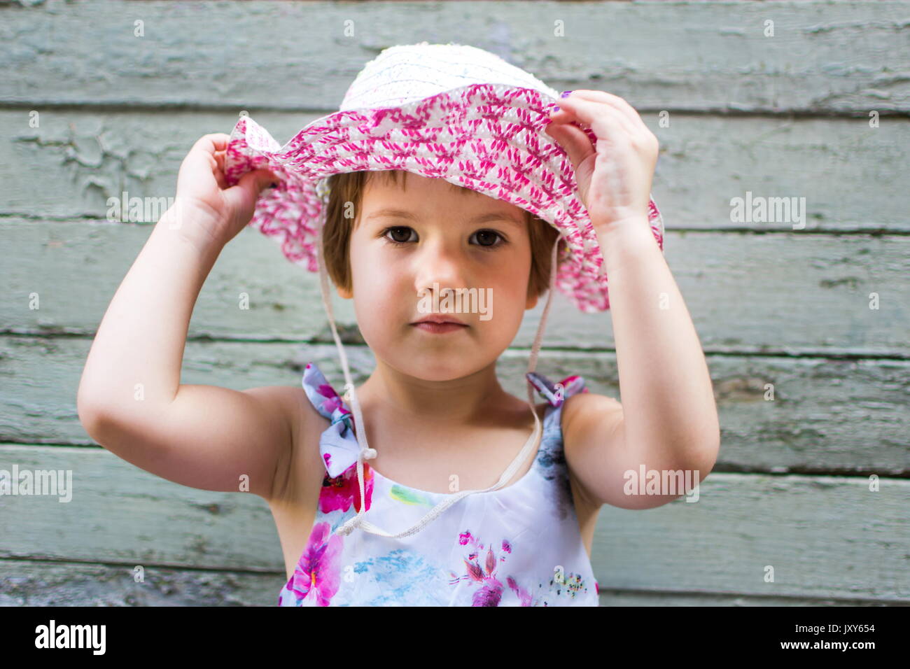 Carino 3 anni ragazza vintage contro uno sfondo di legno Foto Stock