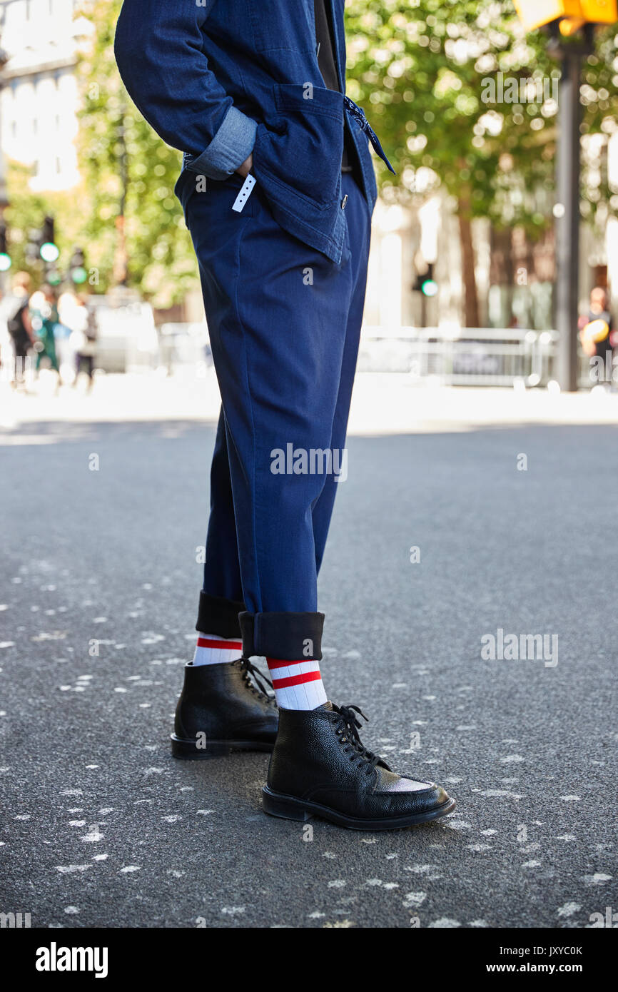 Bassa sezione verticale dell uomo in pantaloni blu e stivali neri Foto Stock