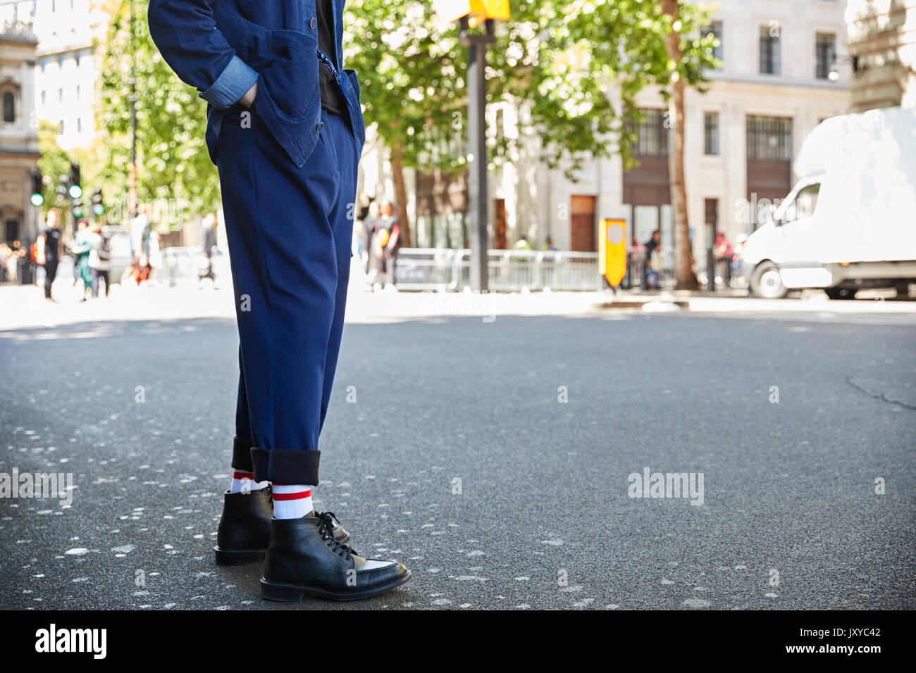 Sezione bassa di un uomo in blu navy pantaloni e stivali neri Foto stock -  Alamy