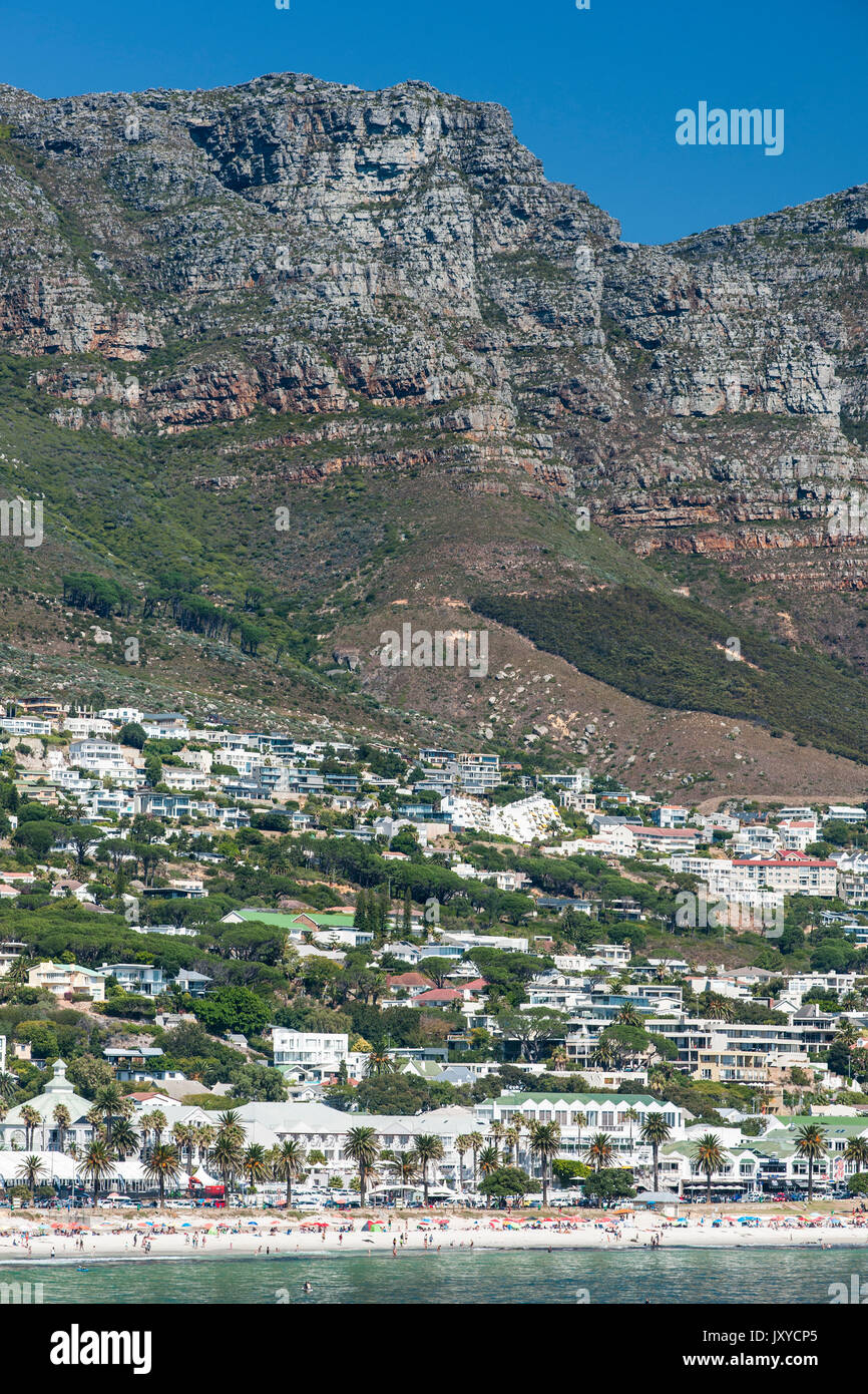 La spiaggia di Camps Bay e di case e alcuni dei picchi dei dodici apostoli montagne di Città del Capo in Sud Africa. Foto Stock