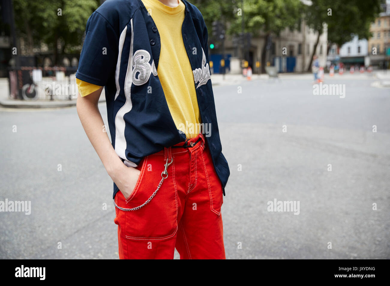 Uomo in un pantaloni rossi con grandi tasche e maglietta di baseball Foto  stock - Alamy