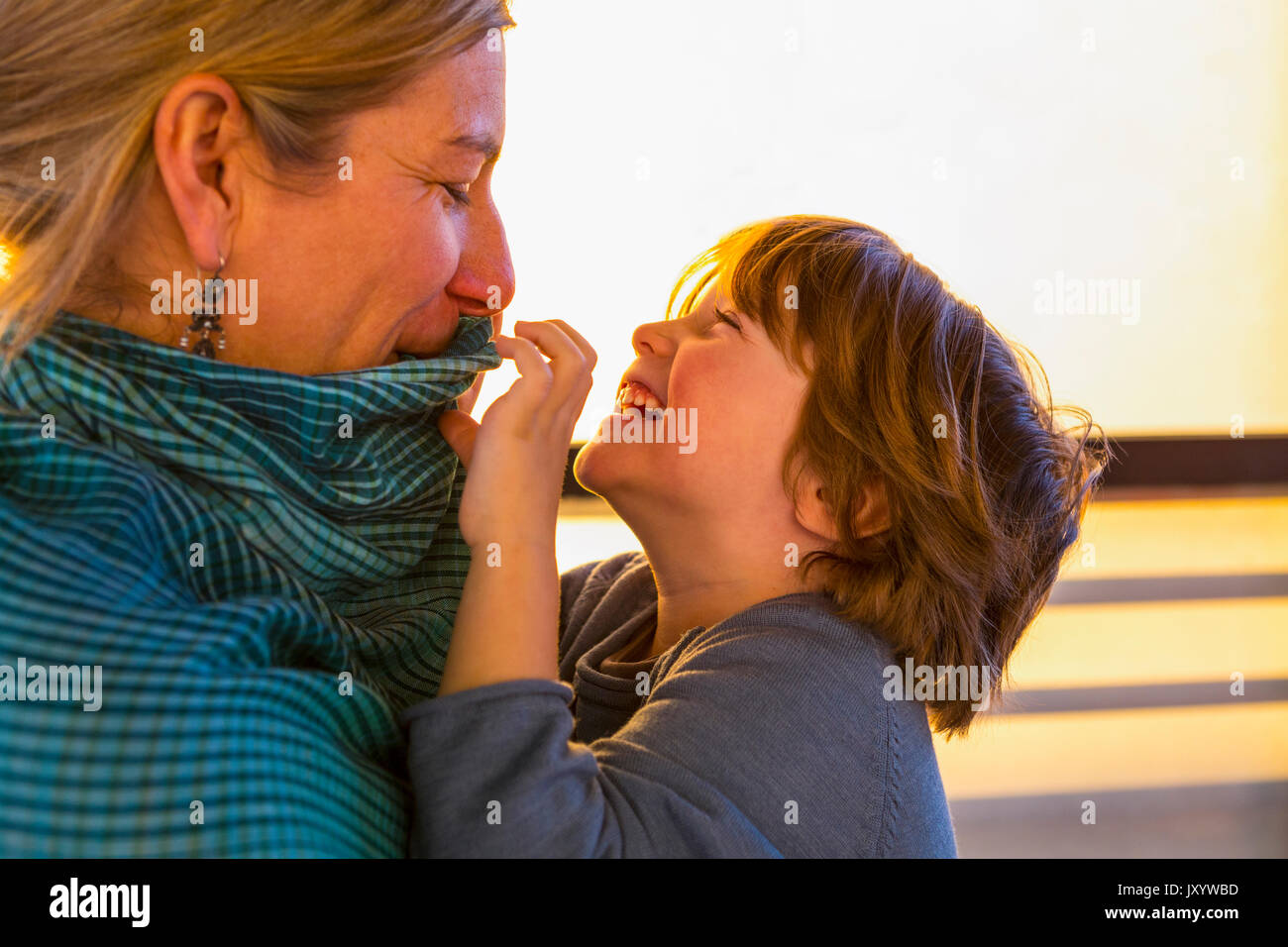Madre caucasica guardando figlio giocare con il suo collare Foto Stock