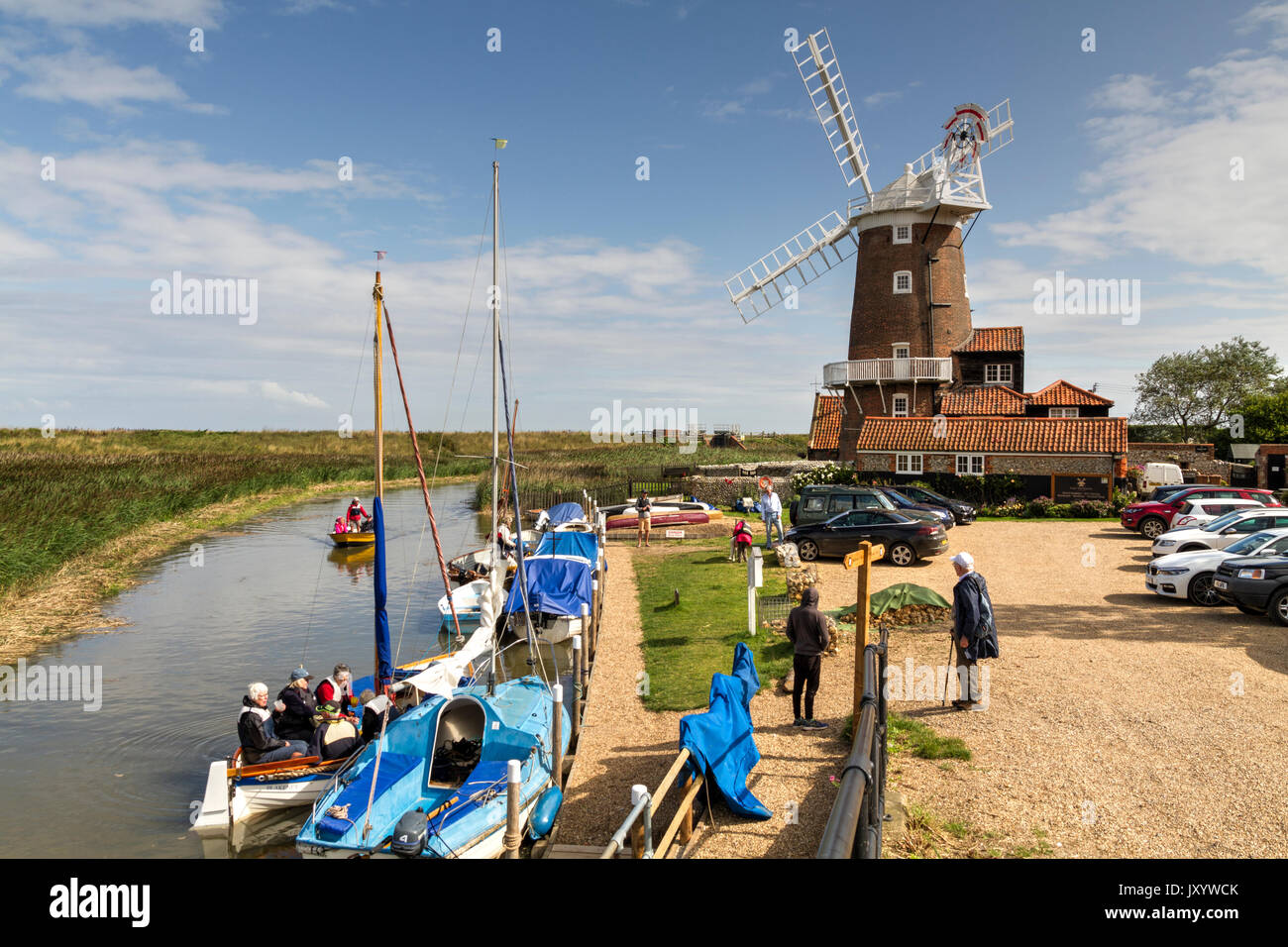 Barche sul fiume Glaven accanto al mulino a vento a Cley accanto il mare Norfolk Foto Stock