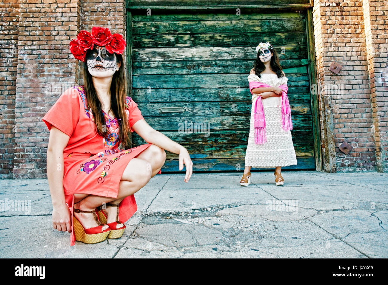 Le donne sul marciapiede che indossa il teschio volto vernice Foto Stock