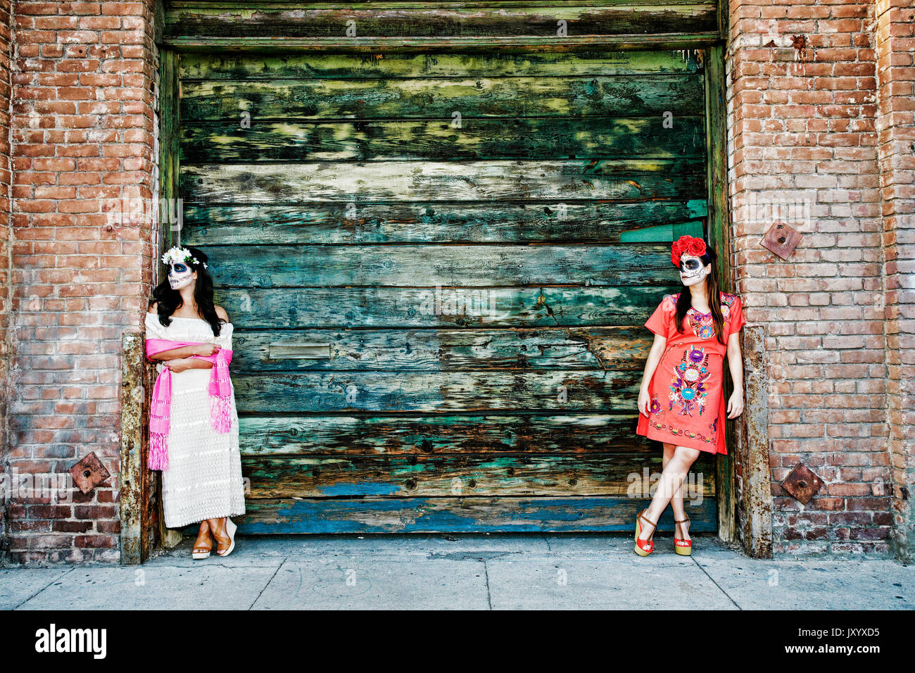 Donne appoggiata sulla banchina di carico che indossa il teschio volto vernice Foto Stock