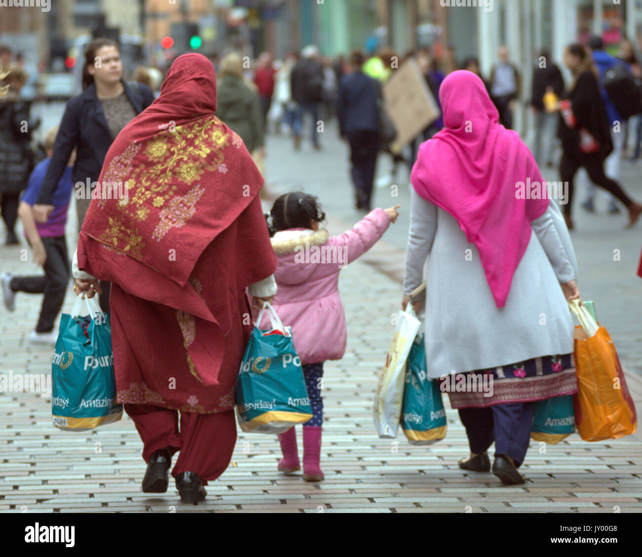 Il pakistan donna asiatica di donne con bambino famiglia shopping bags su Argyle Street Glasgow visto da dietro Foto Stock