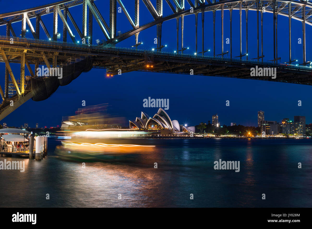 Fiery cercando Ferry al crepuscolo con Harbour Bridge e la Opera House di Sydney, Nuovo Galles del Sud, Australia. Foto Stock