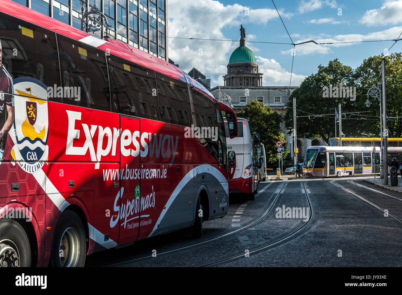 I mezzi di trasporto pubblici, un bus Éireann Expressway autobus e tram Luas è visto in Irlanda la capitale Dublino Foto Stock