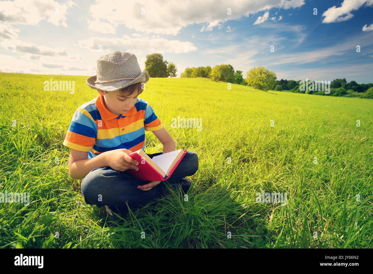 Otto anni bambino la lettura di un libro Foto Stock