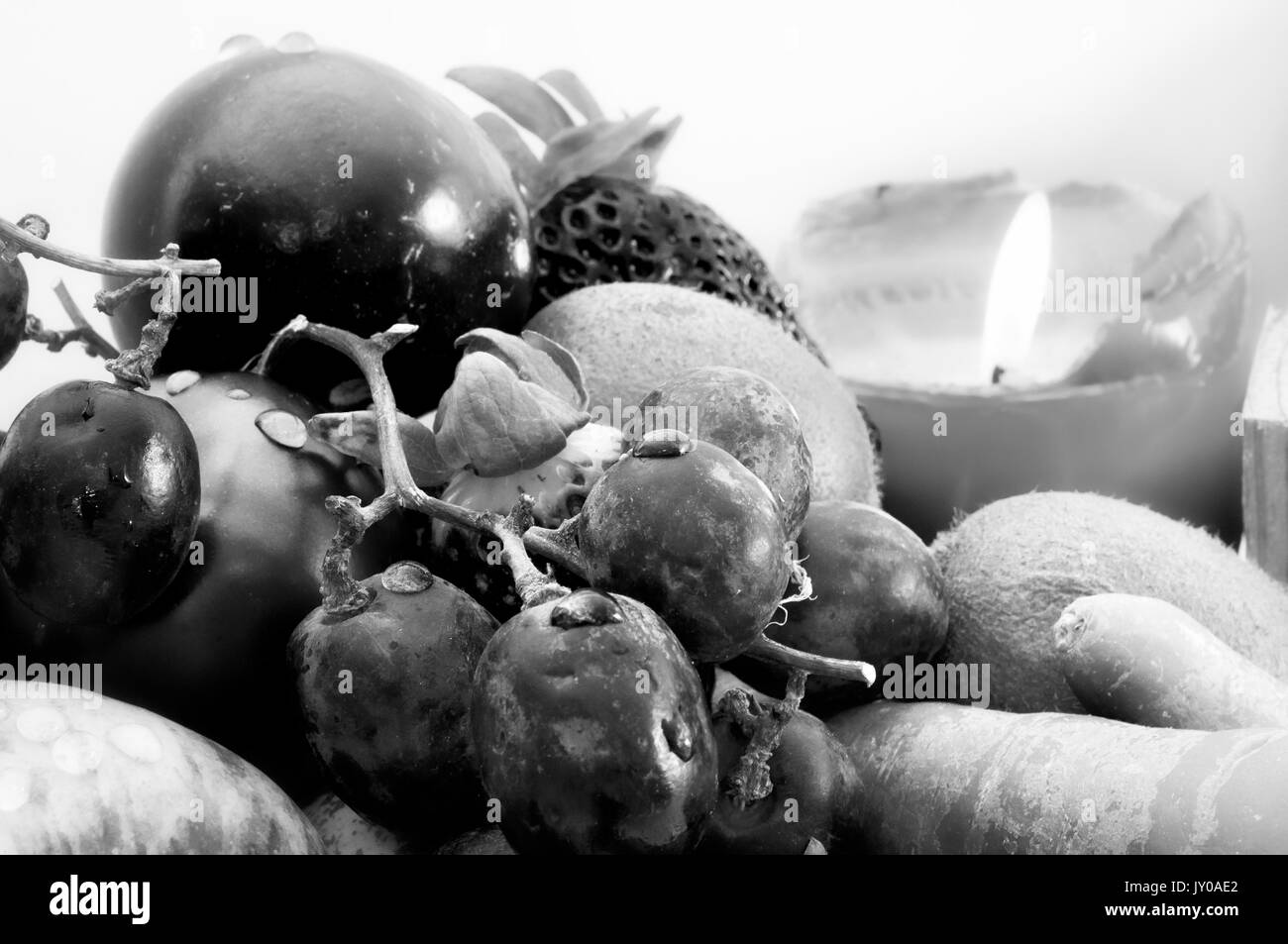 La frutta e la verdura con una candela in background Foto Stock