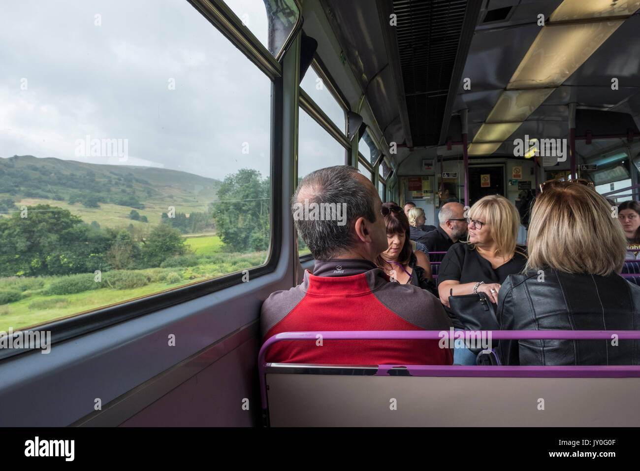 I passeggeri di un treno. Persone che viaggiano attraverso la campagna inglese e sulla speranza linea di valle in valle di Edale, Derbyshire, England, Regno Unito Foto Stock