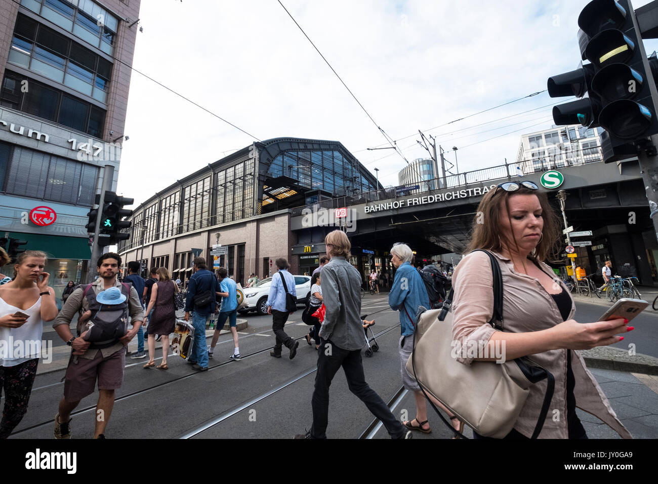 Scena di strada di attraversamento pedonale accanto a Friedrichstrasse stazione ferroviaria di Berlino, Germania Foto Stock