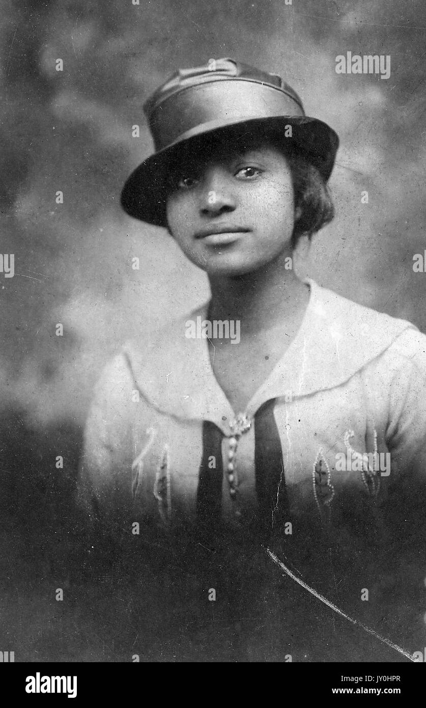 Colpo di testa del giovane africano donna americana, indossa una camicetta di luce con disegni e dark hat, espressione neutra, 1915. Foto Stock