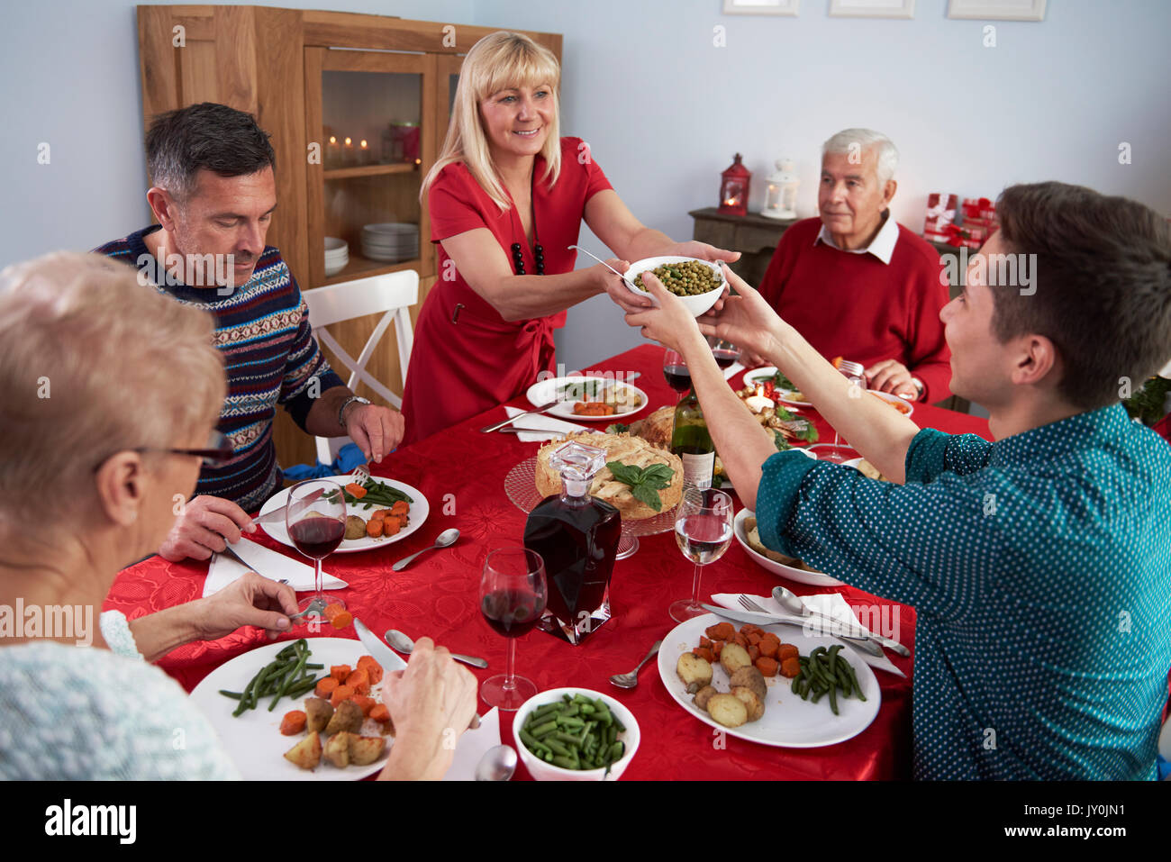 Figlio aiutando la madre alla cena di Natale Foto Stock