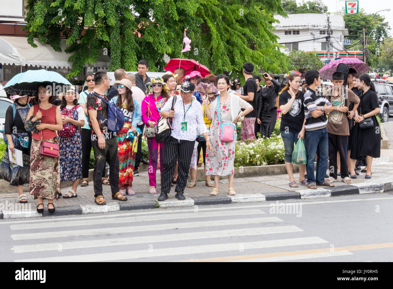 Guida con i turisti cinesi in attesa di attraversare la strada, Bangkok, Thailandia Foto Stock