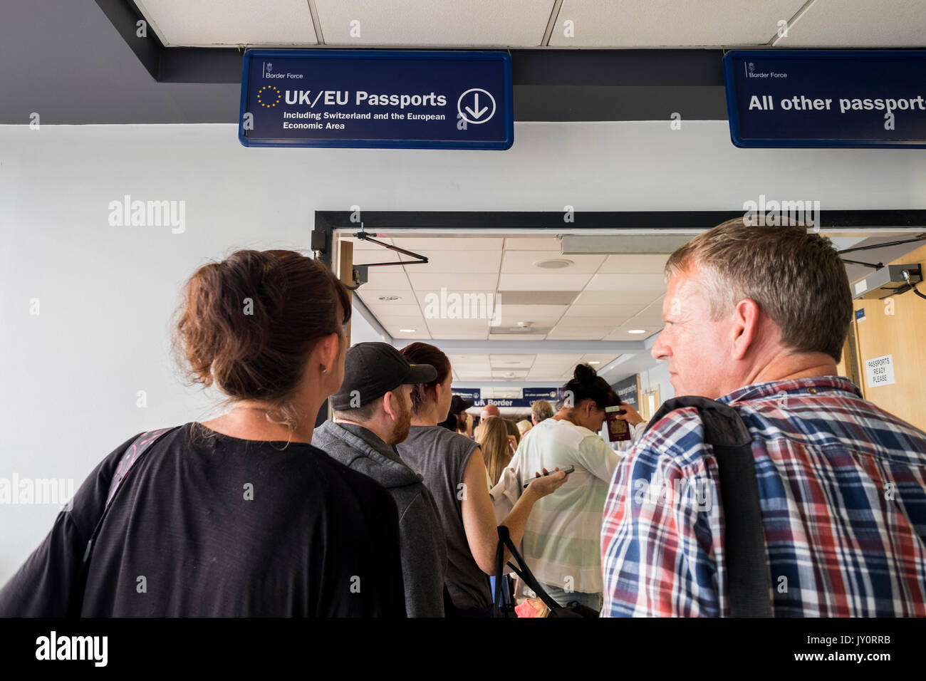 Passeggeri queing per andare attraverso il controllo dei passaporti all'aeroporto di Leeds Bradford, nello Yorkshire, Inghilterra, Regno Unito Foto Stock