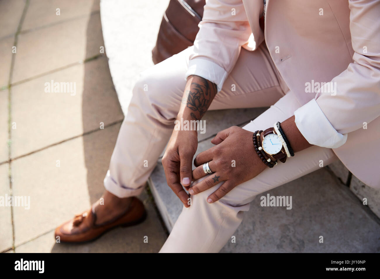 Sezione bassa di un uomo in rosa tuta e scarpe marrone Foto Stock