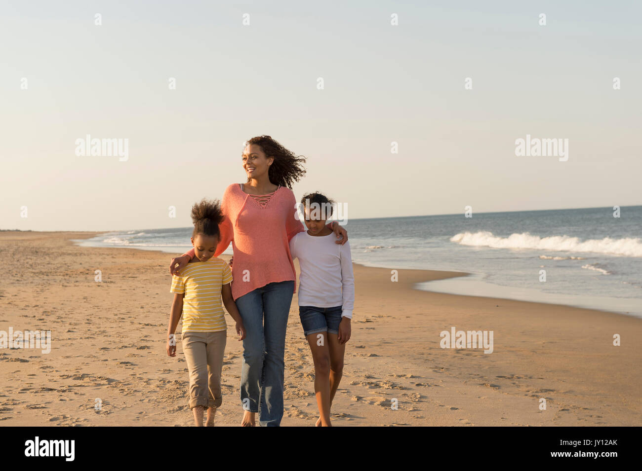 La madre e le figlie camminando sulla spiaggia Foto Stock