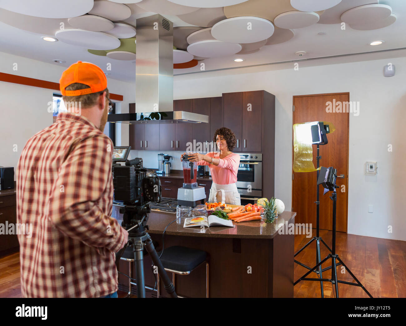 Il cameraman donna registrazione preparare frullati in cucina domestica Foto Stock