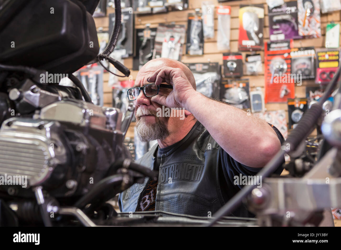Uomo caucasico riparazione moto occhiali di regolazione Foto Stock