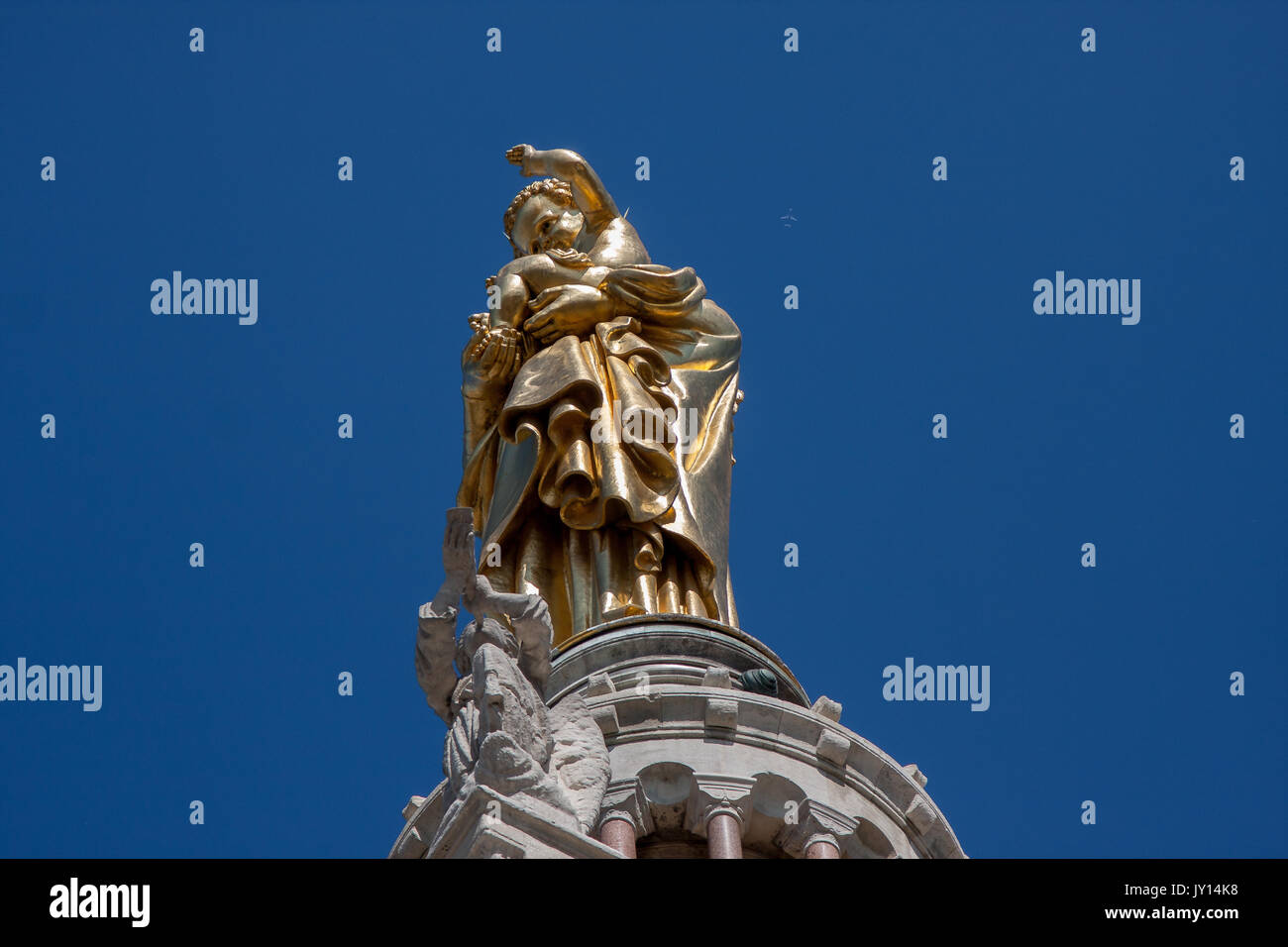 Statua dorata sulla sommità della Basilica di Notre Dame de la Garde con un aeromobile in volo in background. Foto Stock