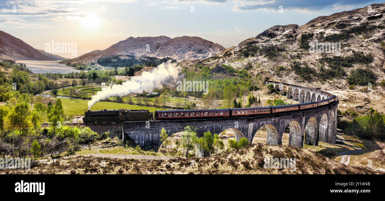 Glenfinnan viadotto ferroviario in Scozia con il vapore giacobita treno contro il tramonto sul lago Foto Stock