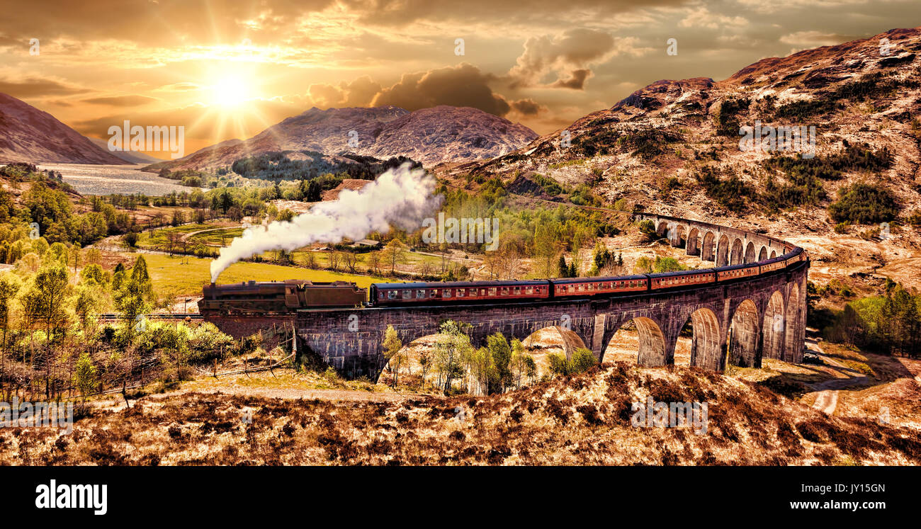 Glenfinnan viadotto ferroviario in Scozia con il vapore giacobita treno contro il tramonto sul lago Foto Stock