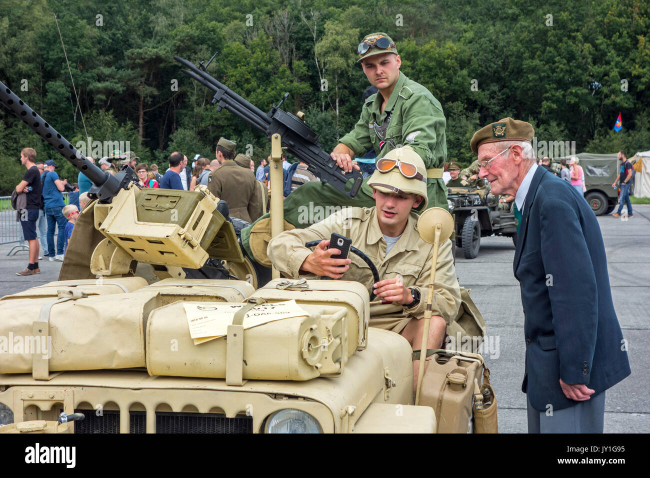 Anziani veterano di guerra a parlare ai giovani WW2 reenactors in WWII jeep con montato Vickers K mitragliatrice durante la Seconda Guerra Mondiale militaria fair Foto Stock