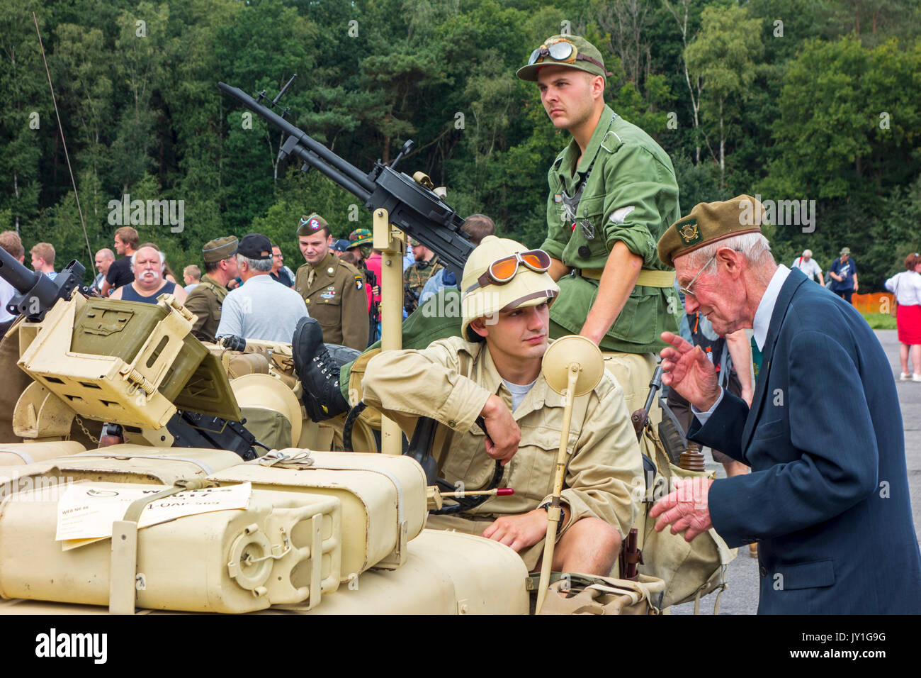 Anziani veterano di guerra a parlare ai giovani WW2 reenactor in WWII jeep con montato Vickers K mitragliatrice durante la Seconda Guerra Mondiale militaria fair Foto Stock