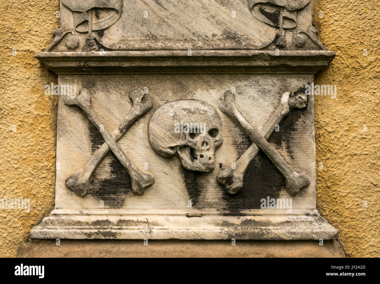 Primo piano di una vecchia tomba nel cimitero di Greyfriar, Candlemaker Row, Edimburgo, Scozia, Regno Unito, con teschio e crossoni simbolici indossati Foto Stock