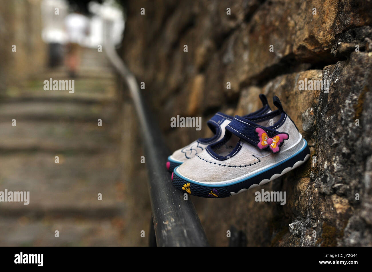 scarpe per bambini appese dal vecchio muro sulla vecchia scala Foto Stock